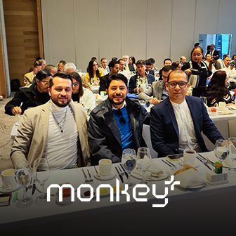 Equipo de Monkey Plus participando en evento corporativo con asistentes en salón de conferencias