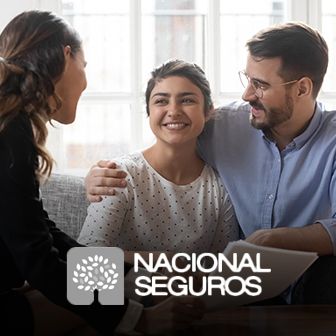 Pareja sonriente conversando con asesora en oficina con logotipo de Nacional Seguros