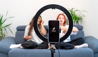 Teléfono grabando un video de TikTok frente a dos jóvenes