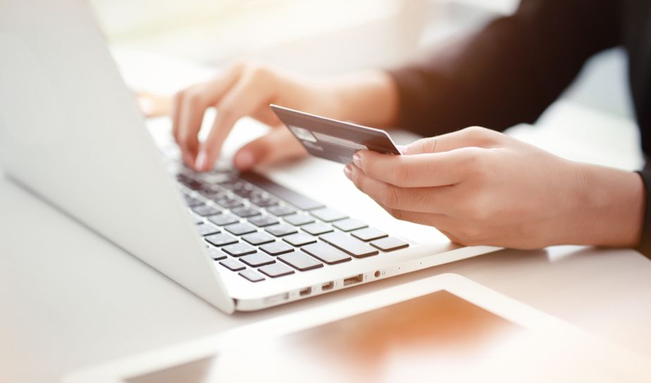 Persona realizando una compra online con tarjeta de crédito en laptop