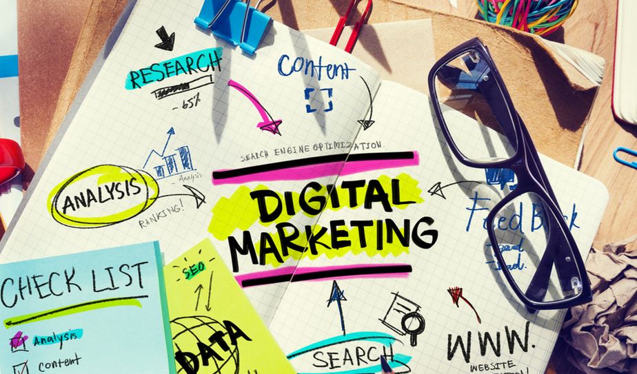 Mesa con notas de colores y cuaderno con apuntes de marketing digital