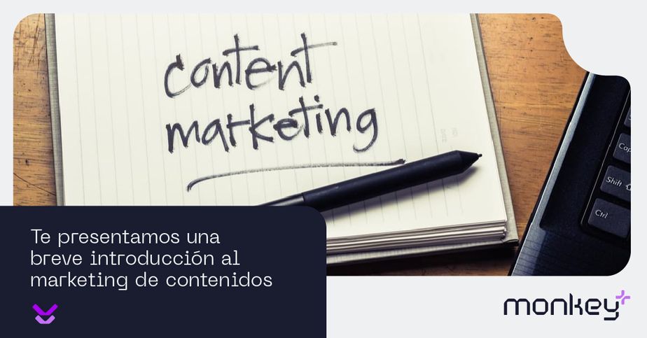 Cuaderno con la frase content marketing y bolígrafo junto a un teclado